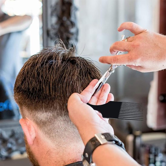Coiffeur professionnel utilisant afro peigne en salon coupe homme