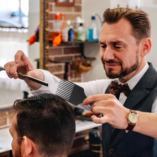 Coiffeur utilisant peigne VintageOil professionnel coupe homme salon