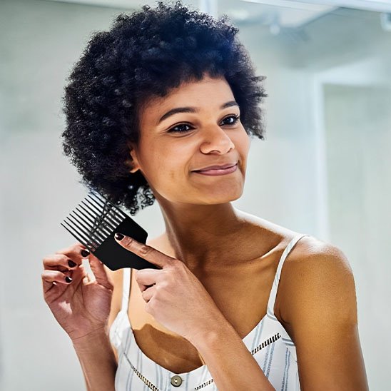 Femme utilisant afro peigne démêlant pour cheveux crépus naturels - DémelCrépusPro