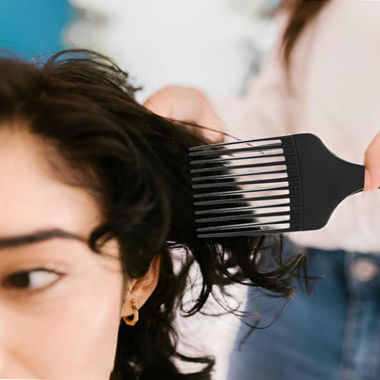 Femme utilisant peigne pick VintageOil démêlage cheveux longs