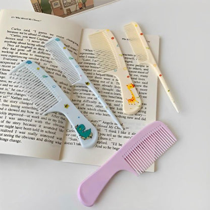 Peignes DemelJunior colorés avec motifs ludiques posés sur livre ouvert