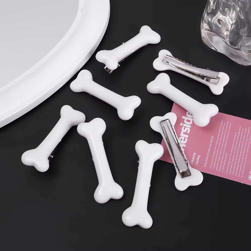 Barrettes cheveux en forme d'os blanches, vues de face et de dos avec clips métalliques